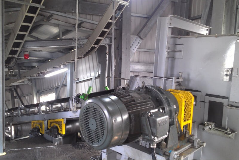 Industrial conveyor motor and gearbox creating mechanical load that can cause VFD overload trips